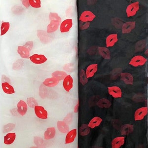 Puede incluir: Dos piezas de tela transparente con labios rojos impresos en ellas. Una pieza es blanca y la otra es negra.