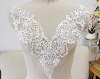 Può includere: Bordino in pizzo bianco con un delicato motivo floreale. Il bordino è perfetto per aggiungere un tocco di eleganza a qualsiasi progetto.