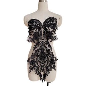May include: Black lace applique with a floral design. The applique is about 10 inches tall and 7 inches wide.