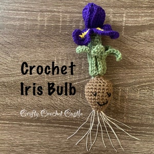 Peut inclure: Un bulbe d'iris crocheté avec une fleur violette et des feuilles vertes. Le bulbe a un visage brun avec un sourire. Le texte "Crochet Iris Bulb" et "Crafty Crochet Castle" est visible.