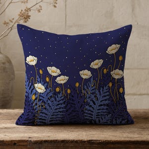 May include: A square throw pillow featuring a deep navy blue background with a pattern of white poppy flowers and dark blue fern-like foliage. The upper portion of the pillow displays a scattering of small white dots resembling a starry night sky.