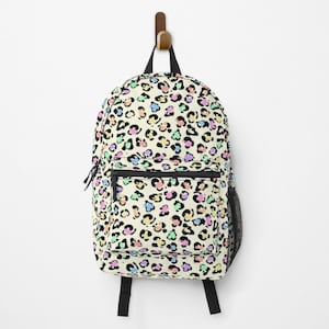 May include: A cream-colored backpack with a colorful leopard print pattern. The print features black spots with pink, blue, green, and yellow accents.