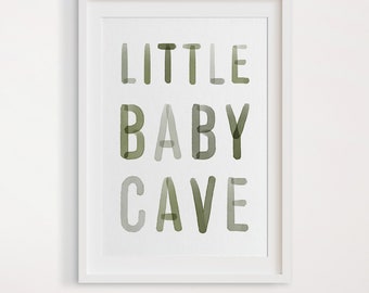 May include: A white framed print with the text "LITTLE BABY CAVE" in green watercolor lettering. The print is on a white background.