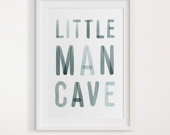 May include: A watercolor print with the text "LITTLE MAN CAVE" in a light blue color. The text is in a bold, blocky font.