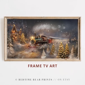 May include: A framed digital art print depicts a vintage train traveling through a snowy forest at night. The train is green and red, with a bright headlight. The scene includes illuminated Christmas trees and a building in the background. Text on the image reads "FRAME TV ART".
