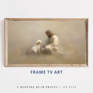May include: A framed artwork depicts a serene scene of a figure in white robes with a lamb. The artwork is in a wooden frame. The text "FRAME TV ART" is displayed below the image.