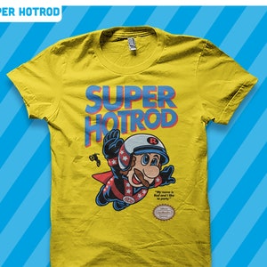 May include: Yellow t-shirt with a blue and red graphic of a cartoon character wearing a helmet and flying. The graphic says "SUPER HOTROD" and "ROD". The text "My name is Rod and I like to party" is below the graphic. The t-shirt has a Nintendo seal of approval.