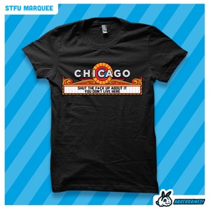 May include: Black t-shirt with a graphic of a red, white, and blue marquee sign that says "CHICAGO" with the text "SHUT THE F*CK UP ABOUT IT YOU DON'T LIVE HERE" underneath.