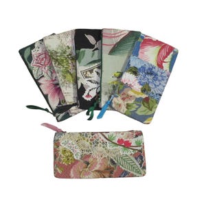 Peut inclure: Une collection de six pochettes rectangulaires en tissu arborant divers motifs floraux et botaniques dans des tons de rose, vert, bleu et noir. Chaque pochette comprend une fermeture éclair avec une petite tirette en tissu sur le côté.