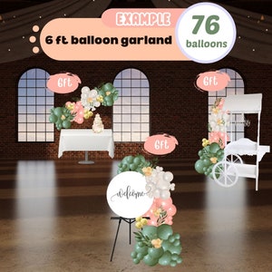 May include: Example of a 6 ft balloon garland with 76 balloons in green, white, and pink colors. The garland is displayed in a room with brick walls and large windows. The garland is decorated with a welcome sign and a small cake.