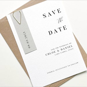 Puede incluir: Tarjeta de guardar la fecha con fondo blanco y texto negro. La tarjeta dice "Save the Date" para la boda de Chloe & Daniel, Lago de Garda, Italia. La fecha es 09.03.2023.
