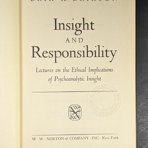 May include: Open book with the title "Insight and Responsibility" by Erik H. Erikson. The cover is cream-colored with black text. The book's publisher is W. W. Norton & Company, Inc., New York. There is a signature at the top.