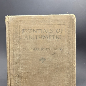 May include: A vintage brown book titled "Essentials of Arithmetic" with the words "Grammar School Book" and "Wentworth-Smith" printed on the cover.