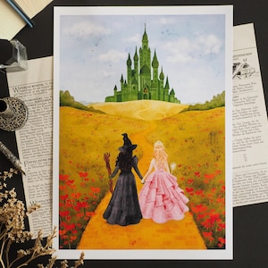 Op de afbeelding: Aquarel kunstafdruk met twee figuren die hand in hand lopen op een gele weg naar een groen kasteel. Het pad is omzoomd met rode bloemen. Eén figuur draagt een zwarte jurk en hoed, de andere een roze jurk.