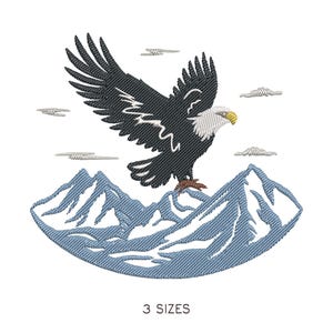 May include: An embroidered design featuring a bald eagle with outstretched wings, perched atop a mountain range. The eagle is black and white with a yellow beak. The mountains are blue, and the sky has small cloud details. The text "3 SIZES" is at the bottom.