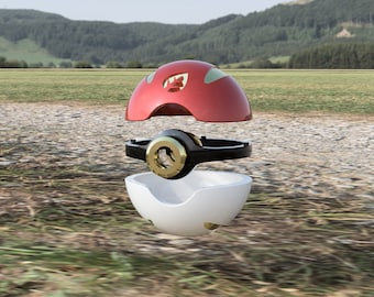 Op de afbeelding: Een rood en wit Poke Ball speelgoed met een zwarte en gouden ring. Het speelgoed is gedemonteerd in drie delen, wat de interne werking van de bal laat zien.