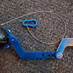 May include: A blue plastic tool with a black sphere attached to one end. The tool has a hook on the other end and a string attached to the sphere. The tool is designed for retrieving objects from hard-to-reach places.