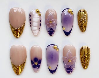 Unhas francesas douradas e roxas em formato de amêndoa alongada/ Unhas com flores roxas em formato de flor/ Unhas cromadas douradas/ Unhas douradas/ Unhas para festas/ Unhas de aniversário