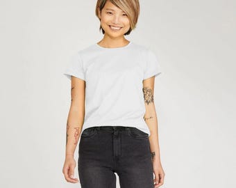 May include: A white t-shirt with a crew neck and short sleeves. The model is wearing black jeans.