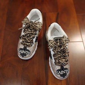 Black & gold rhinestone sneakers for women,Hand beaded,Who Dat letters, Nola football patches. Fleur De lis fancy laces. Local design 150.