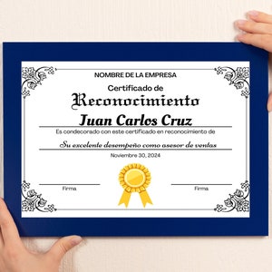 Op de afbeelding: Een ingelijst certificaat met een marineblauwe rand. Het certificaat luidt "Certificado de Reconocimiento" en wordt toegekend aan Juan Carlos Cruz voor uitstekende prestaties als verkoopadviseur. De datum op het certificaat is 30 november 2024.