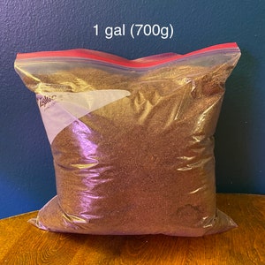 May include: A clear plastic bag filled with brown soil. The bag is sealed with a red zipper. The bag is labeled "1 gal (700g)".