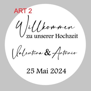 May include: White circle with black text that says "Art 2" in red, "Willkommen zu unserer Hochzeit" and "Valentina & Antonio" in cursive, and "25 Mai 2024".
