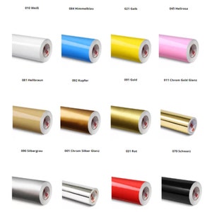 May include: A selection of 12 rolls of vinyl adhesive film in various colors, including white, light blue, yellow, pink, light brown, copper, gold, chrome gold, silver gray, chrome silver, red, and black. Each roll is labeled with a number and a color name in German.