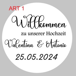May include: White round sticker with black text that says "Art 1" in the top left corner. The text "Willkommen zu unserer Hochzeit Valentina & Antonio 25.05.2024" is in a decorative font.