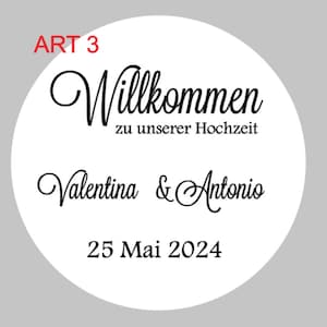 May include: White circle with black text that says "Willkommen zu unserer Hochzeit" and "Valentina & Antonio" with the date "25 Mai 2024" below. The text "ART 3" is in red at the top of the circle.