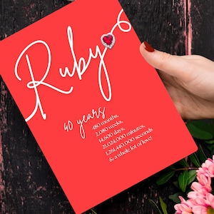Op de afbeelding: Een felrode wenskaart met de witte scripttekst Ruby, een hartvormig rood edelsteenpictogram en de tekst 40 years, 480 months, 2,080 weeks, 14,600 days, 21,024,000 minutes, 1,261,440,000 seconds, and a whole lot of love!