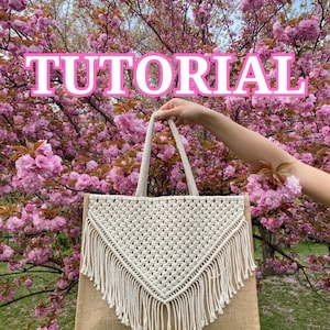 以下が含まれることがあります： ピンクの桜の木の前で、フリンジのついた白いマクラメのトートバッグを持っています。バッグは茶色のジュートの底で、結び目のデザインで作られています。画像には「TUTORIAL」というテキストが重ねられています。