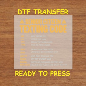May include: A yellow and white graphic with the text "DTF TRANSFER" at the top and "A SENIOR CITIZEN TEXTING CODE" below. The graphic lists abbreviations and their meanings, such as "BFF" for "Best Friend Fell" and "TTH" for "Talk To You Louder". The graphic ends with the text "READY TO PRESS" in yellow.