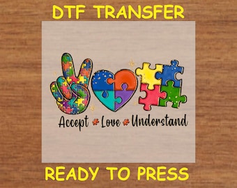 May include: A colourful peace sign made of jigsaw pieces with a heart in the middle. The text "Accept * Love * Understand" is below the peace sign. The image is labelled "DTF Transfer" and "Ready to Press".