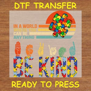 May include: A DTF transfer design featuring a colorful puzzle piece with a sunset background and the text "In a world where you can be anything, be kind". The design also includes a sign language interpretation of the word "kind".