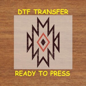 May include: A DTF transfer sheet with a geometric design in black, red, and white. The design is a stylized diamond shape with a distressed look. The text "DTF TRANSFER" is at the top of the sheet and "READY TO PRESS" is at the bottom.