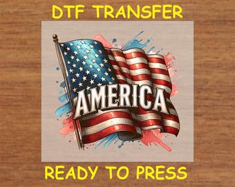 May include: A DTF transfer design featuring a vintage-style American flag with the word "AMERICA" in bold lettering. The flag is surrounded by colorful watercolor splatters. The design is ready to press.