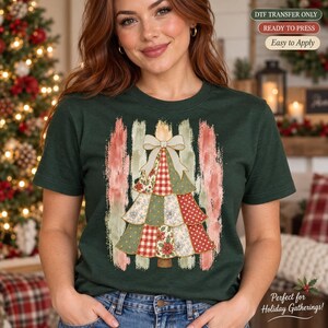 May include: A dark green t-shirt featuring a graphic of a stylized Christmas tree made of various patterned fabric patches, topped with a large white bow, set against vertical brushstroke textures in muted red, green, and cream colors.