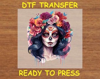 May include: A DTF transfer design featuring a woman with a sugar skull makeup design and a floral crown. The design is ready to press.