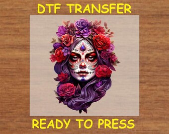 Könnte beinhalten: DTF-Transfer mit einem Tag der Toten Zuckerschädel-Design. Der Schädel ist mit einem floralen Kranz aus roten und violetten Rosen geschmückt. Der Text "READY TO PRESS" wird darunter angezeigt.