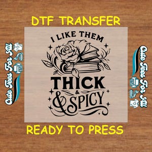 May include: A black and white design on a clear sheet, ready to be pressed onto fabric. The design features a rose, books, and the text "I like them thick & spicy".