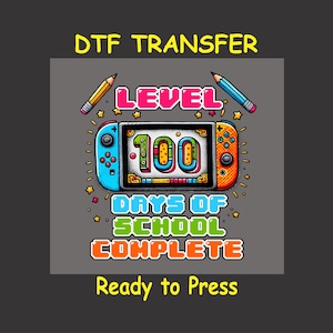 May include: A colorful graphic design featuring a video game controller with a screen that reads "Level 100 Days of School Complete". The design is surrounded by stars and pencils. The text "Ready to Press" is below the design.
