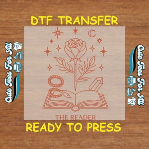 May include: A DTF transfer with a rose, snake, and crystal design. The image includes the text "DTF TRANSFER", "THE READER", and "READY TO PRESS". The design is in shades of orange and is surrounded by stars and a crescent moon.