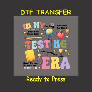 May include: A colorful graphic design with the text "IN MY TESTING ERA" in a retro font. The design includes various school-themed icons like a globe, apple, pencil, and trophy. The text "DTF TRANSFER" and "Ready to Press" are also included.