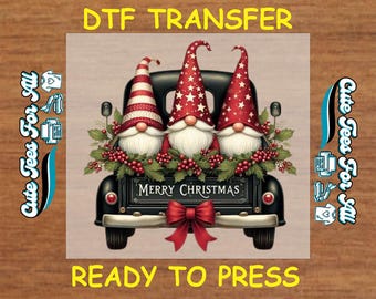Könnte beinhalten: DTF-Transfer mit drei Wichteln in einer schwarzen Ladefläche, geschmückt mit Grün und Beeren. Die Wichtel tragen rot-weiße Hüte, und die Ladefläche trägt die Aufschrift "MERRY CHRISTMAS". Der Text "DTF TRANSFER" und "READY TO PRESS" sind ebenfalls vorhanden.