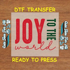 May include: A DTF transfer with the words "JOY TO THE world" in red and green, with "DTF TRANSFER" and "READY TO PRESS" in yellow. The phrase "Cute Tees For All" is on the left and right sides of the design.