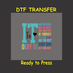 May include: A gray background with the text "DTF TRANSFER" in yellow. The text "It is okay to" is in blue with a heart symbol. The words "make mistakes, not be okay, have hard days, be yourself, not know it all, ask for help, start over, need time more" are stacked vertically in different colors. The text "Ready to Press" is in yellow at the bottom.
