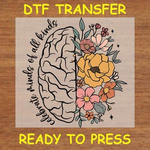May include: A DTF transfer design featuring a brain outline with floral details. The text "Celebrate minds of all kinds" is written on the left side of the brain. The design is ready to press.