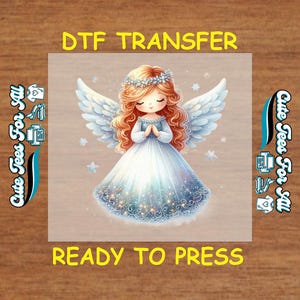 May include: DTF transfer featuring a cartoon angel with flowing red hair, a floral crown, and large white wings. The angel wears a blue and white dress. The text "DTF TRANSFER" and "READY TO PRESS" are displayed in yellow.