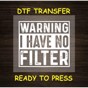 May include: A white iron-on transfer sheet with the text "WARNING I HAVE NO FILTER" in a distressed font. The text is surrounded by a black rectangle. The sheet is ready to press.